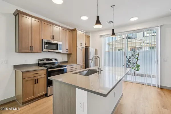 a kitchen with stainless steel appliances granite countertop a stove a sink and a refrigerator