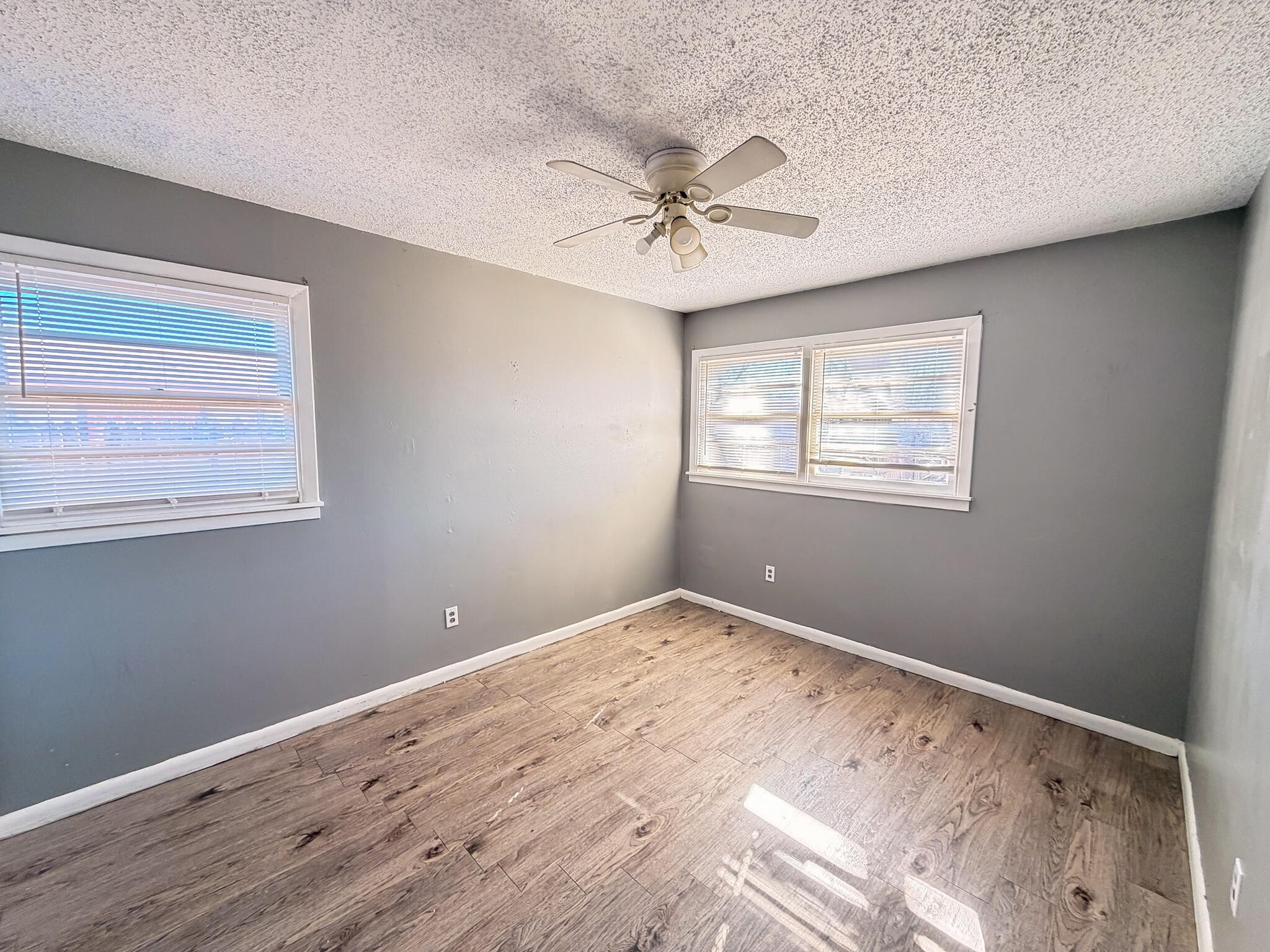 2805 53rd Street Lubbock, TX 79413 - Photo 7 of 13 a view of a big room with wooden floor and windows in a room
