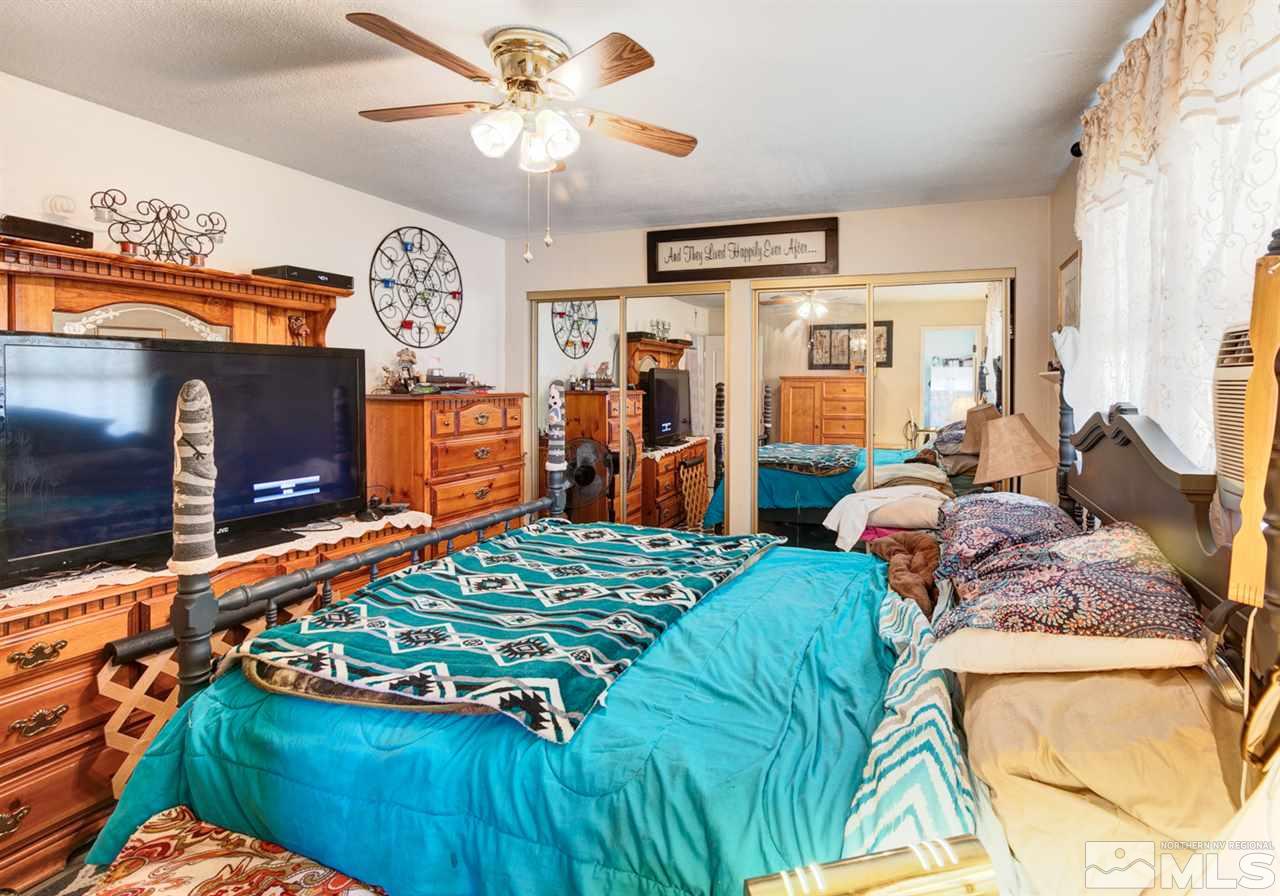 1096 Rice Road Fallon, NV 89406 - Photo 13 of 24 a bedroom with a bed and dresser with mirror