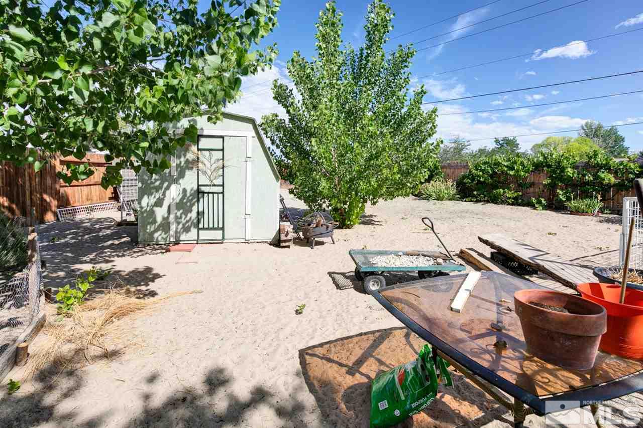 1096 Rice Road Fallon, NV 89406 - Photo 21 of 24 a view of a patio with table and chairs with wooden fence and plants