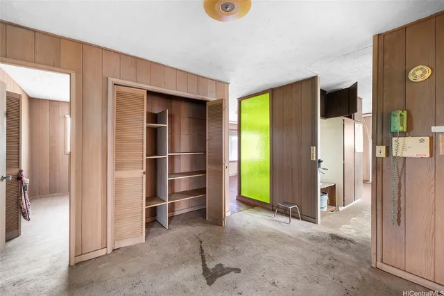 a view of a livingroom with kitchen and front door