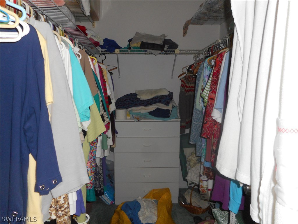 8470 Robin Road Fort Myers, FL 33967 - Photo 18 of 24 a view of walk in closet with clothes and shoes