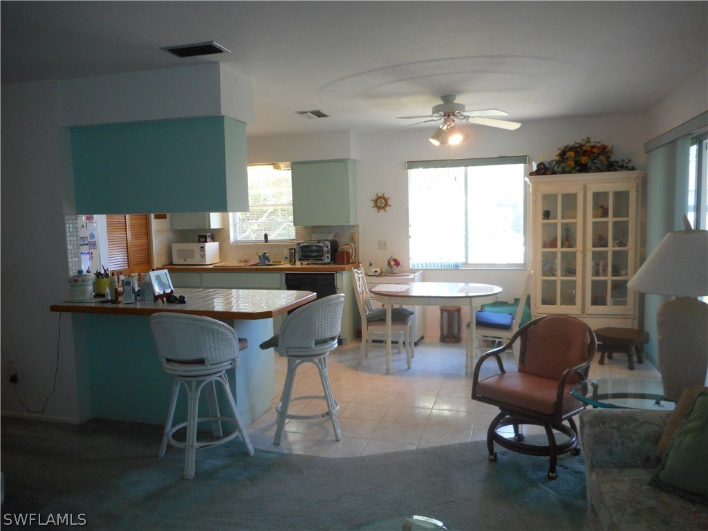 8470 Robin Road Fort Myers, FL 33967 - Photo 7 of 24 a kitchen with granite countertop a table chairs stove a sink dishwasher and a computer