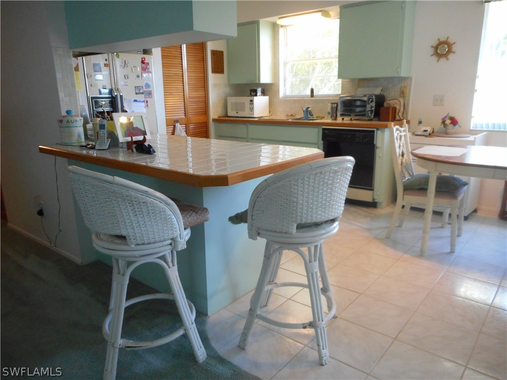 8470 Robin Road Fort Myers, FL 33967 - Photo 8 of 24 a kitchen with granite countertop a table chairs stove and sink