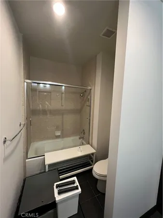 a bathroom with a granite countertop toilet a sink and a shower