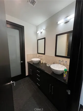 a bathroom with a double vanity sink and a mirror