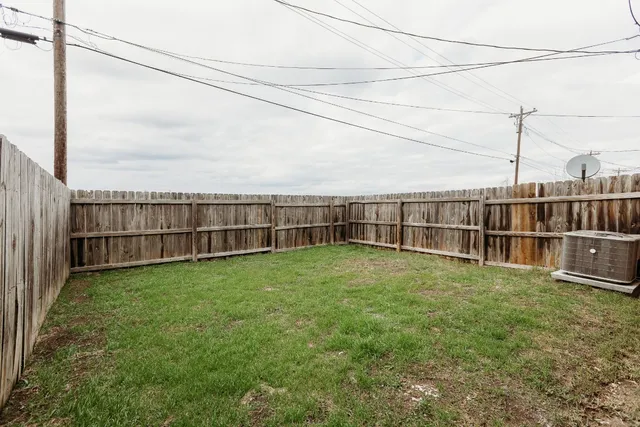 a view of a yard with wooden fence