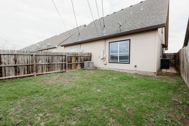 a backyard of a house with wooden fence