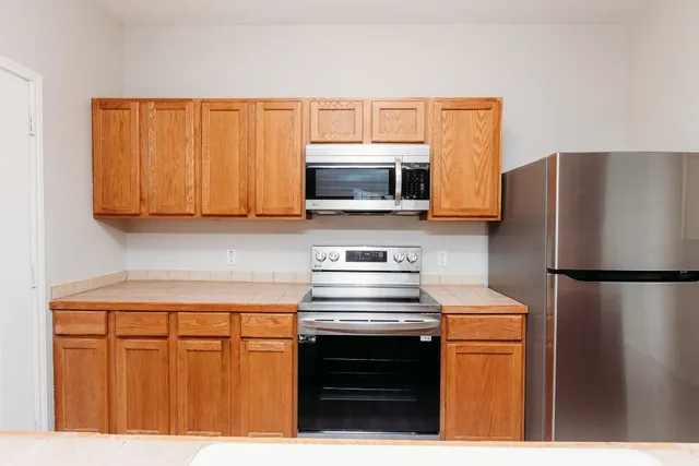 a kitchen with stainless steel appliances white cabinets and a stove top oven