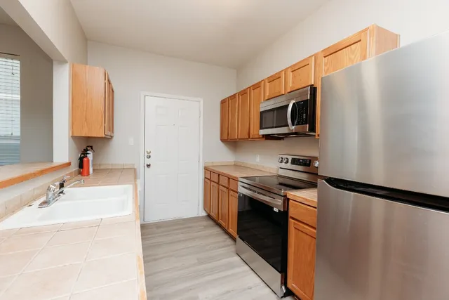 a kitchen with stainless steel appliances a stove microwave and sink