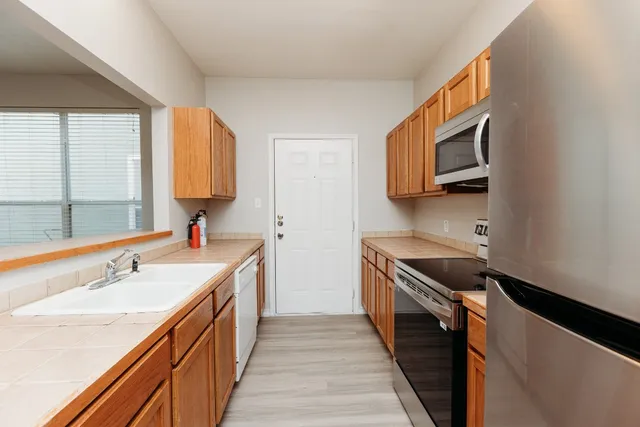 a kitchen with stainless steel appliances granite countertop a sink and a stove