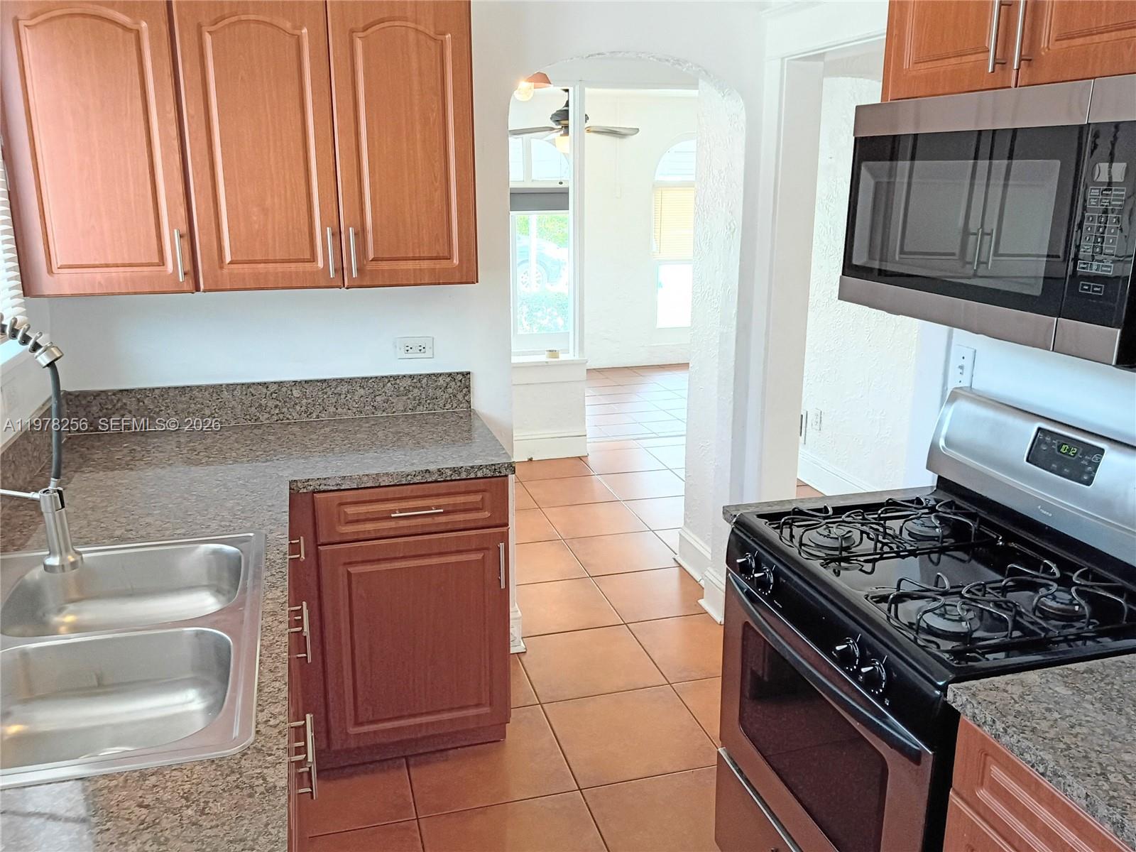 2346 Southwest 20th Street Miami, FL 33145 - Photo 6 of 14 a kitchen with granite countertop a stove and a sink