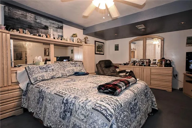 a bedroom with bed and a large window