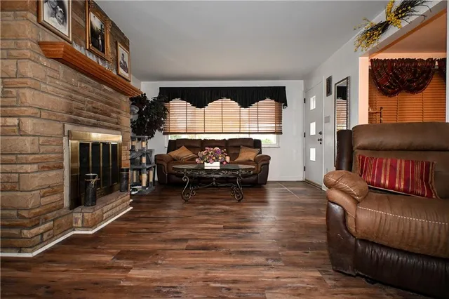 a living room with furniture a flat screen tv and a floor to ceiling window