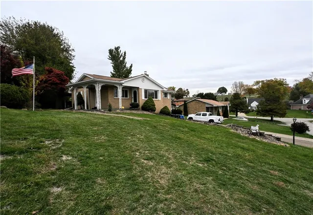 a front view of a house with a garden and trees