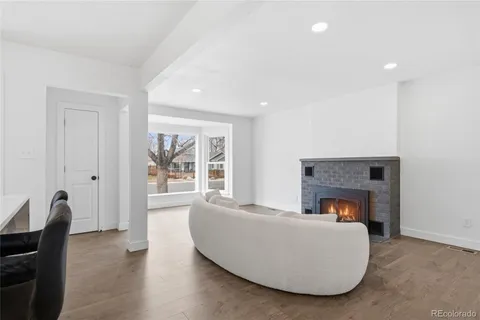 a kitchen with stainless steel appliances granite countertop a dining table chairs and a refrigerator