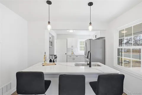 a kitchen with a sink a refrigerator and cabinets