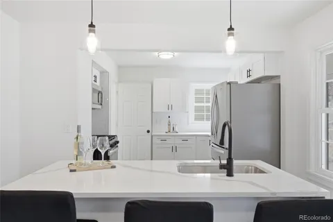 a kitchen with stainless steel appliances granite countertop a sink a stove a refrigerator and a window