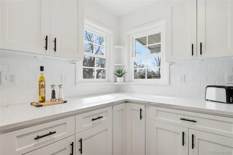 a kitchen with a sink a counter space and living room