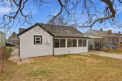 a white house that has a tree in front of it