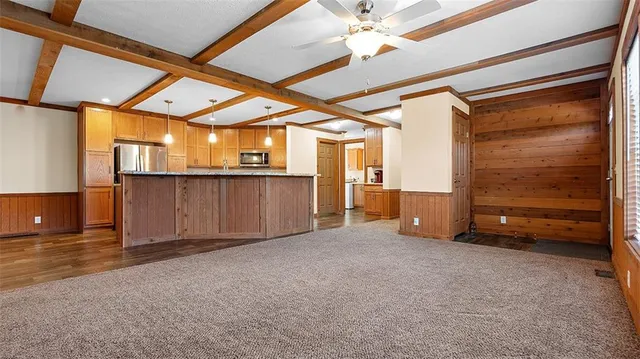 an empty room with windows and chandelier fan