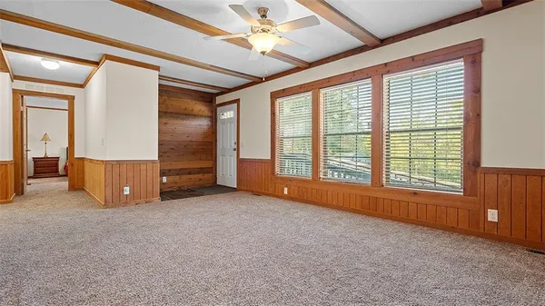an empty room with windows fireplace and a flat tv screen
