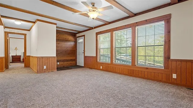 an empty room with windows fireplace and a flat tv screen