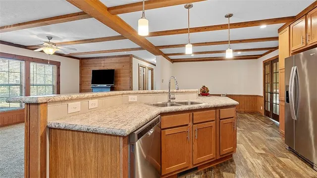 a kitchen with stainless steel appliances granite countertop a stove refrigerator sink and microwave