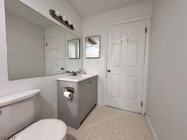 a bathroom with a sink vanity mirror and toilet