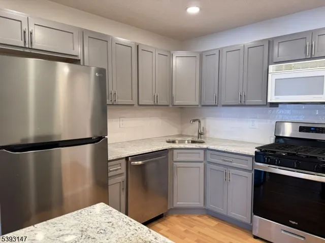 a kitchen with a refrigerator sink and cabinets
