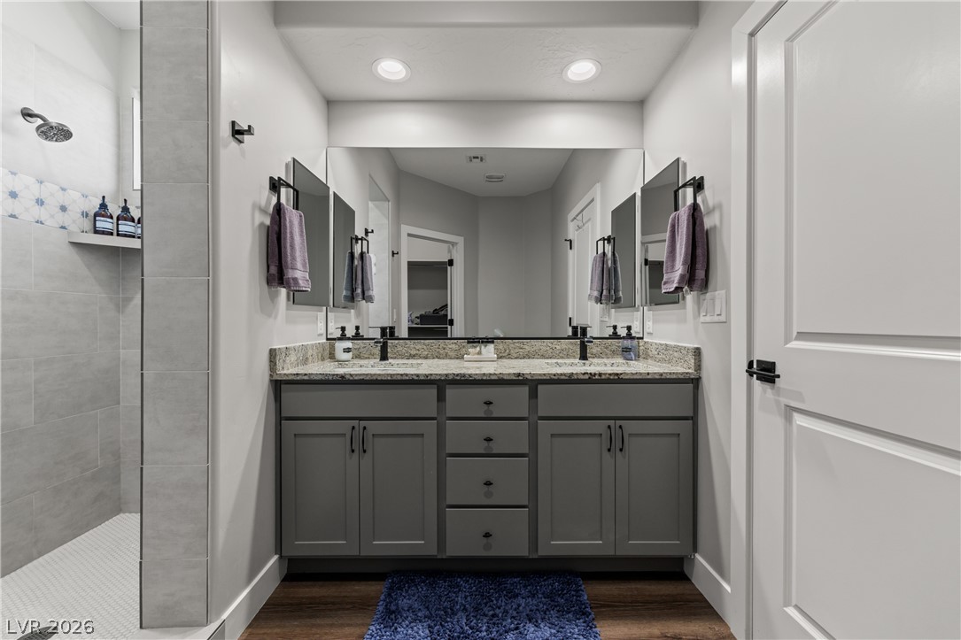 1436 Manassas Ridge Mesquite, NV 89027 - Photo 40 of 77 Double vanity with stone counters and a spacious walk-in shower elevate this well-appointed bathroom.