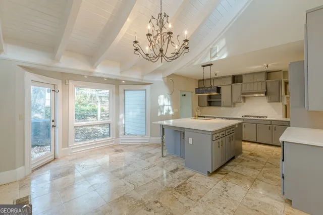 a kitchen with stainless steel appliances a stove a sink dishwasher a refrigerator and white cabinets with wooden floor