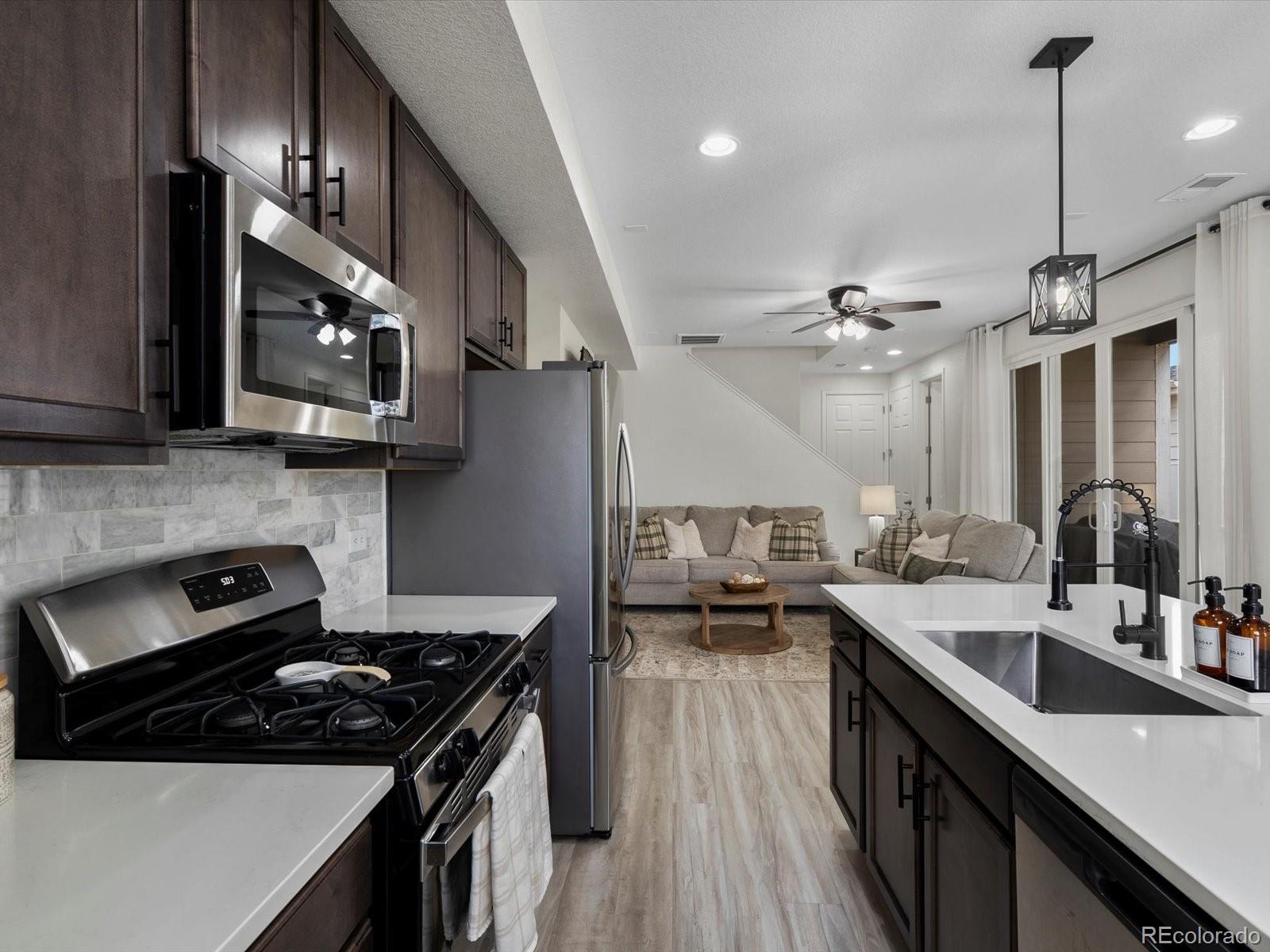 5347 Warrior Street Frederick, CO 80504 - Photo 11 of 48 a kitchen with stainless steel appliances a sink stove and refrigerator