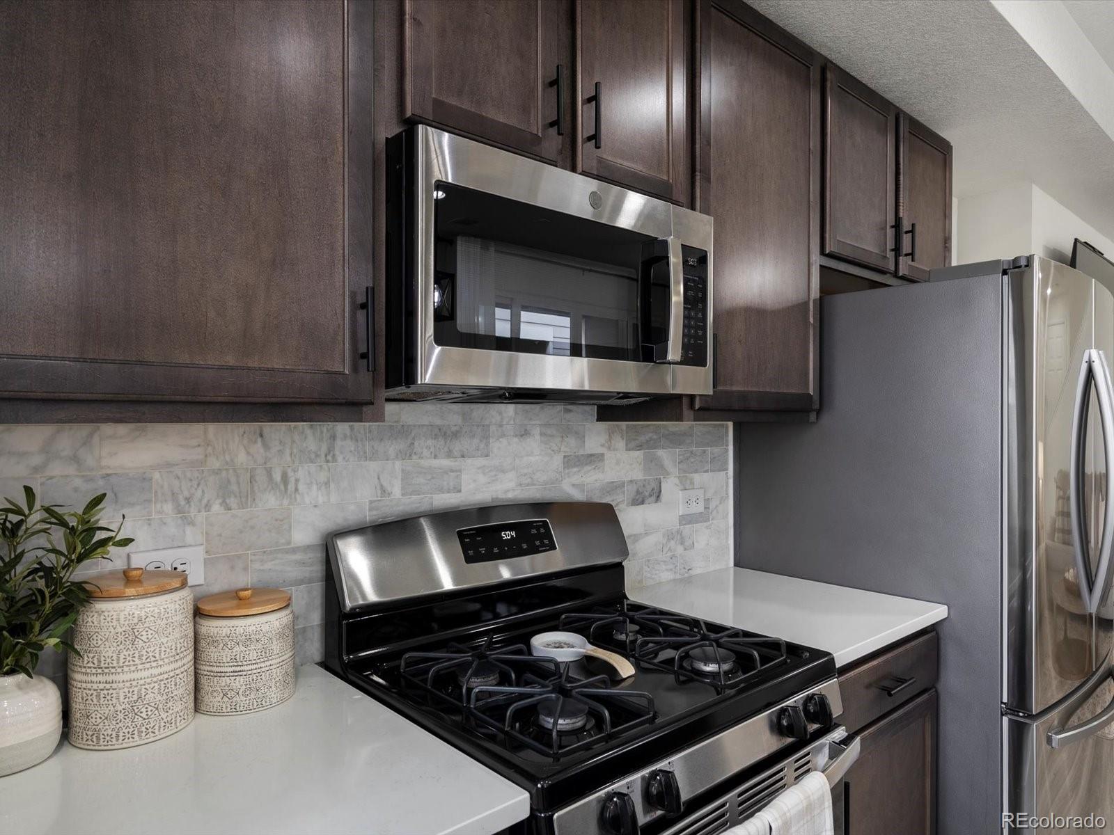 5347 Warrior Street Frederick, CO 80504 - Photo 13 of 48 a kitchen with a stove and a microwave