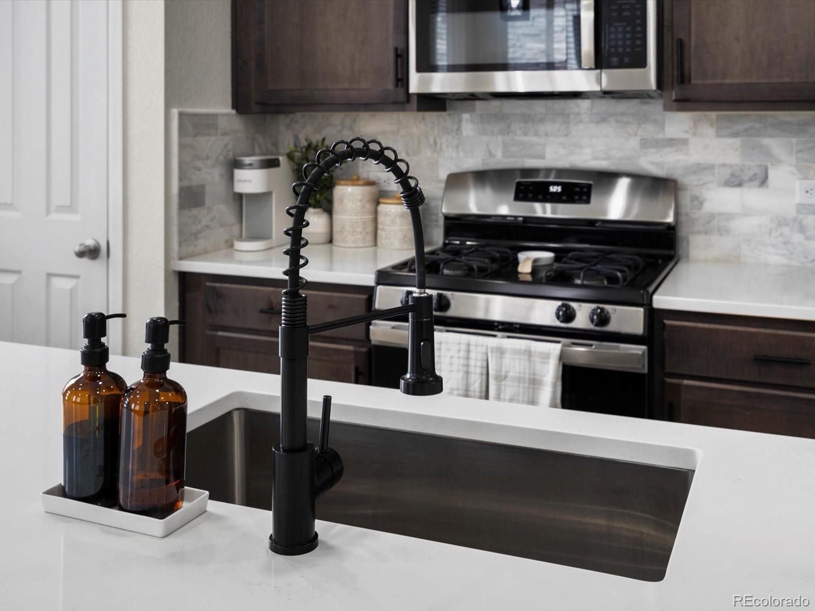 5347 Warrior Street Frederick, CO 80504 - Photo 16 of 48 a kitchen with a stove and a microwave