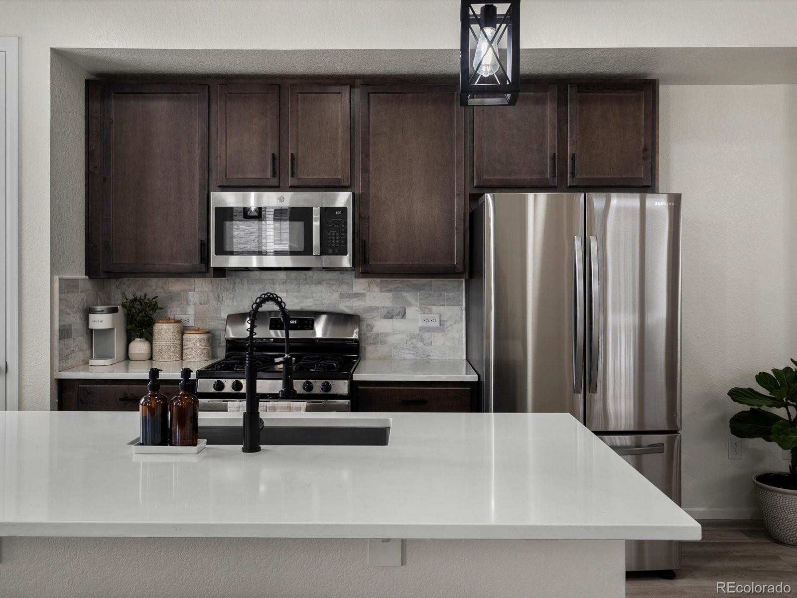 5347 Warrior Street Frederick, CO 80504 - Photo 17 of 48 a kitchen with stainless steel appliances a refrigerator a stove a microwave and cabinets