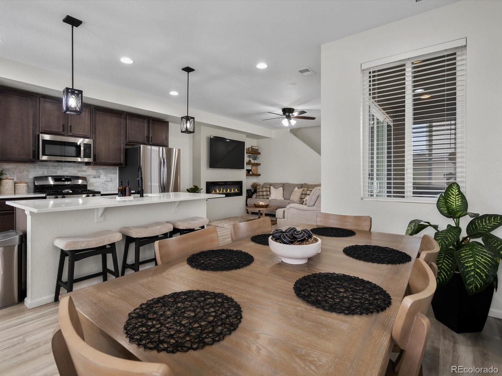 5347 Warrior Street Frederick, CO 80504 - Photo 20 of 48 a kitchen with a stove a microwave a dining table and chairs