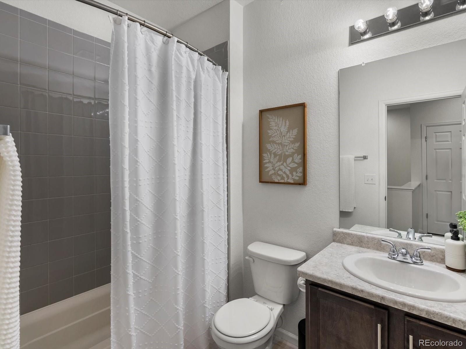 5347 Warrior Street Frederick, CO 80504 - Photo 34 of 48 a bathroom with a sink a toilet and shower