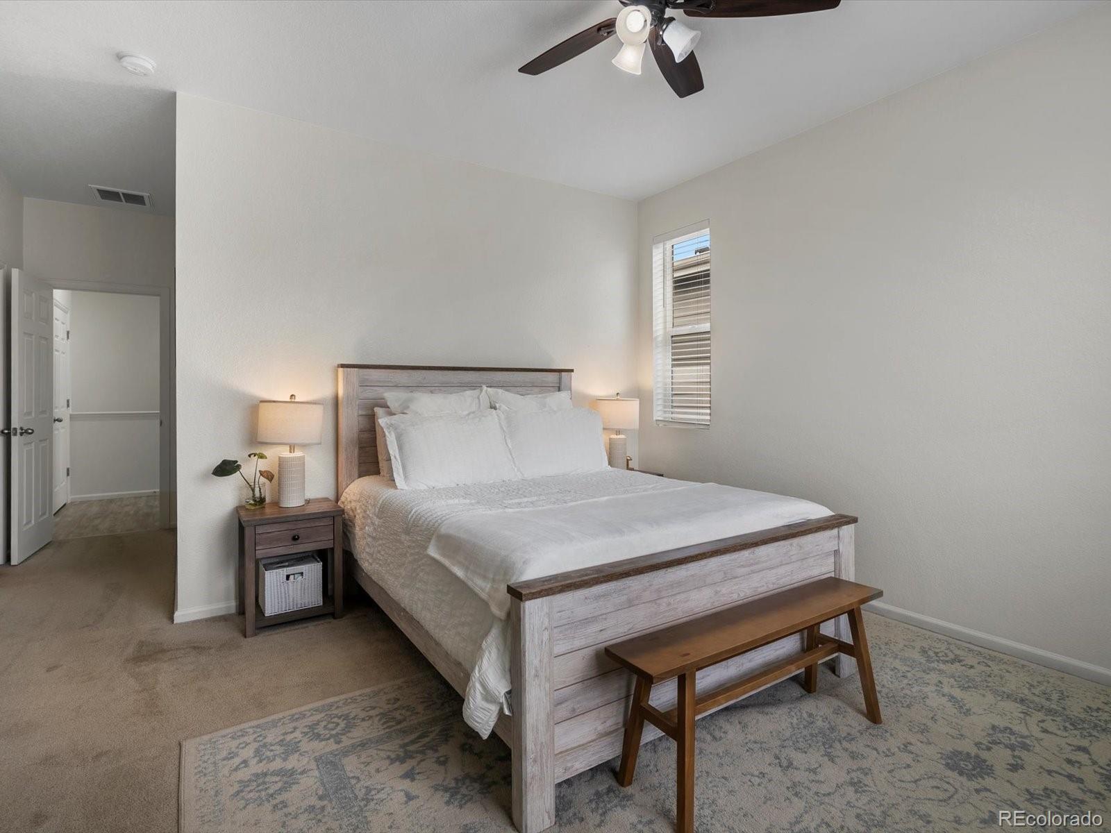 5347 Warrior Street Frederick, CO 80504 - Photo 39 of 48 a bedroom with a bed and a chandelier