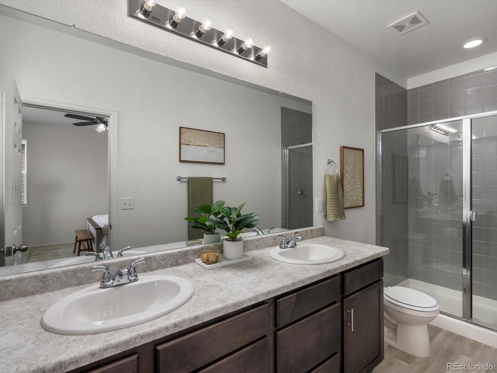 5347 Warrior Street Frederick, CO 80504 - Photo 41 of 48 a bathroom with a granite countertop sink toilet and shower