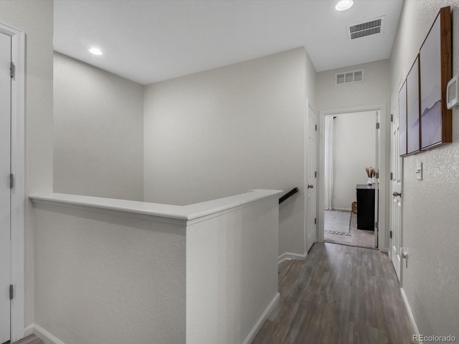 5347 Warrior Street Frederick, CO 80504 - Photo 45 of 48 a view of a hallway with wooden floor and a refrigerator