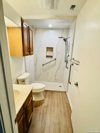 a bathroom with a sink a toilet and shower