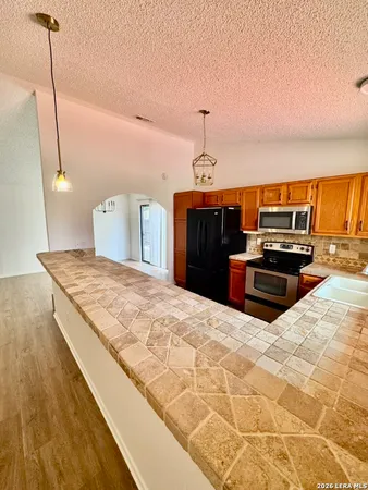 a kitchen with kitchen island a counter top space appliances and cabinets