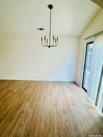 a view of empty room with wooden floor and ceiling fan