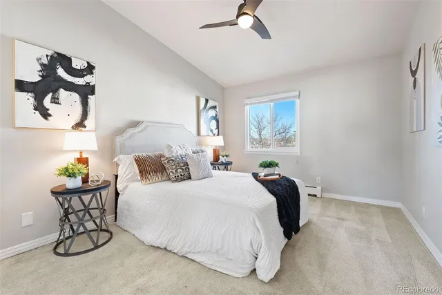 a bed room with a bed and a painting on the wall