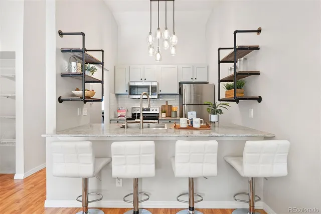 a kitchen with stainless steel appliances granite countertop counter top space and a living room view