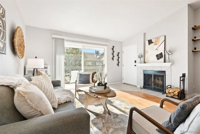 a living room with furniture fireplace and a large window