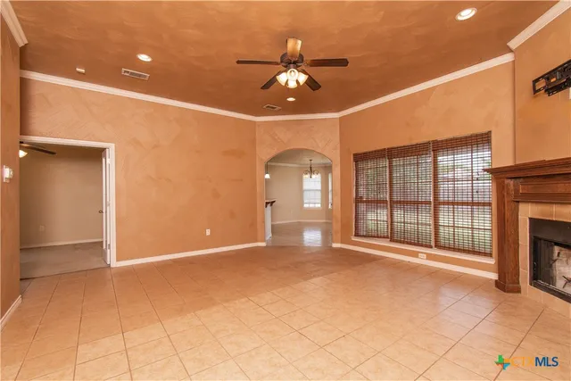 a view of an empty room with a fireplace and a chandelier