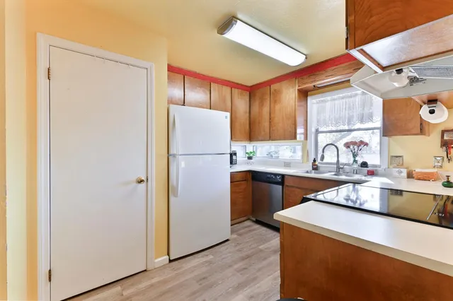 a kitchen with a refrigerator sink and cabinets