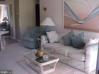 0 Edward Taylor Road, Unit 60 Ocean City, MD 21842 - Photo 3 of 4 a living room with furniture and a lamp